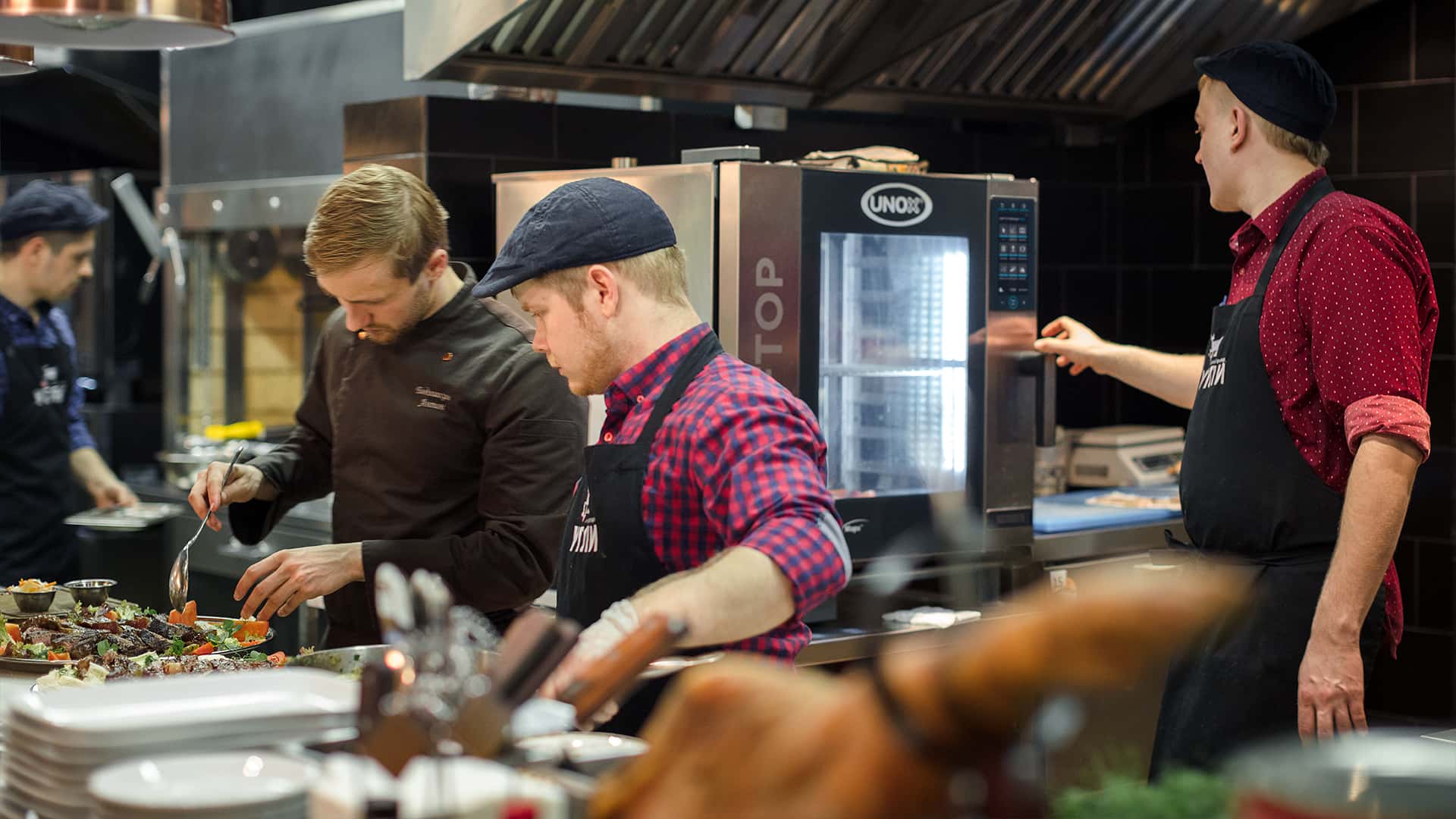 Brigata al lavoro con un forno professionale in cucina